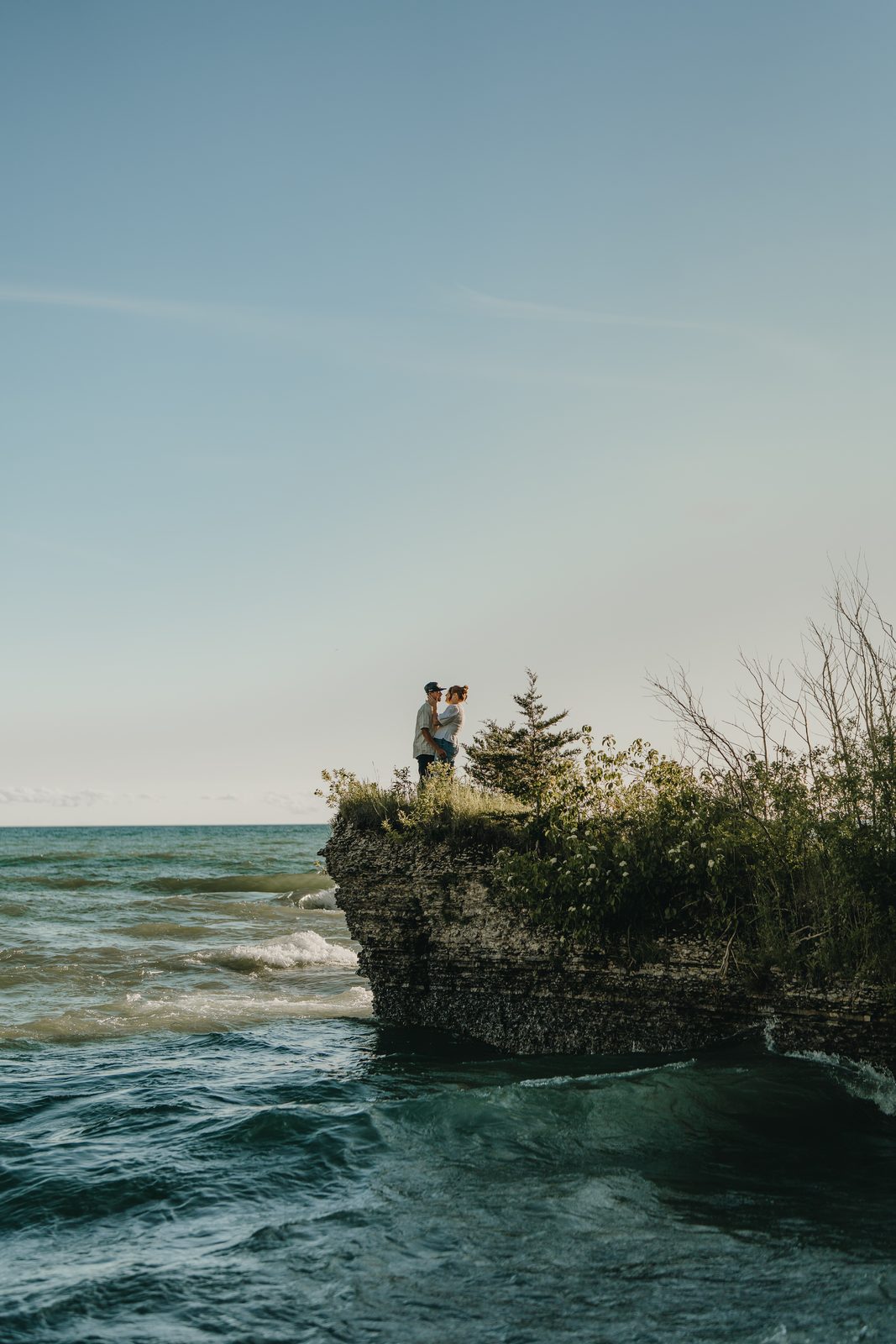 Backlit engagement photo of a couple by Lake Ontario at Point Petre, PEC