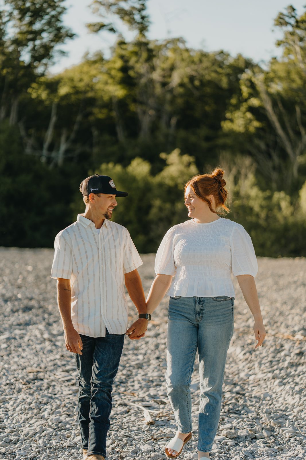 Couple standing together at the water's edge during a Point Petre engagement shoot