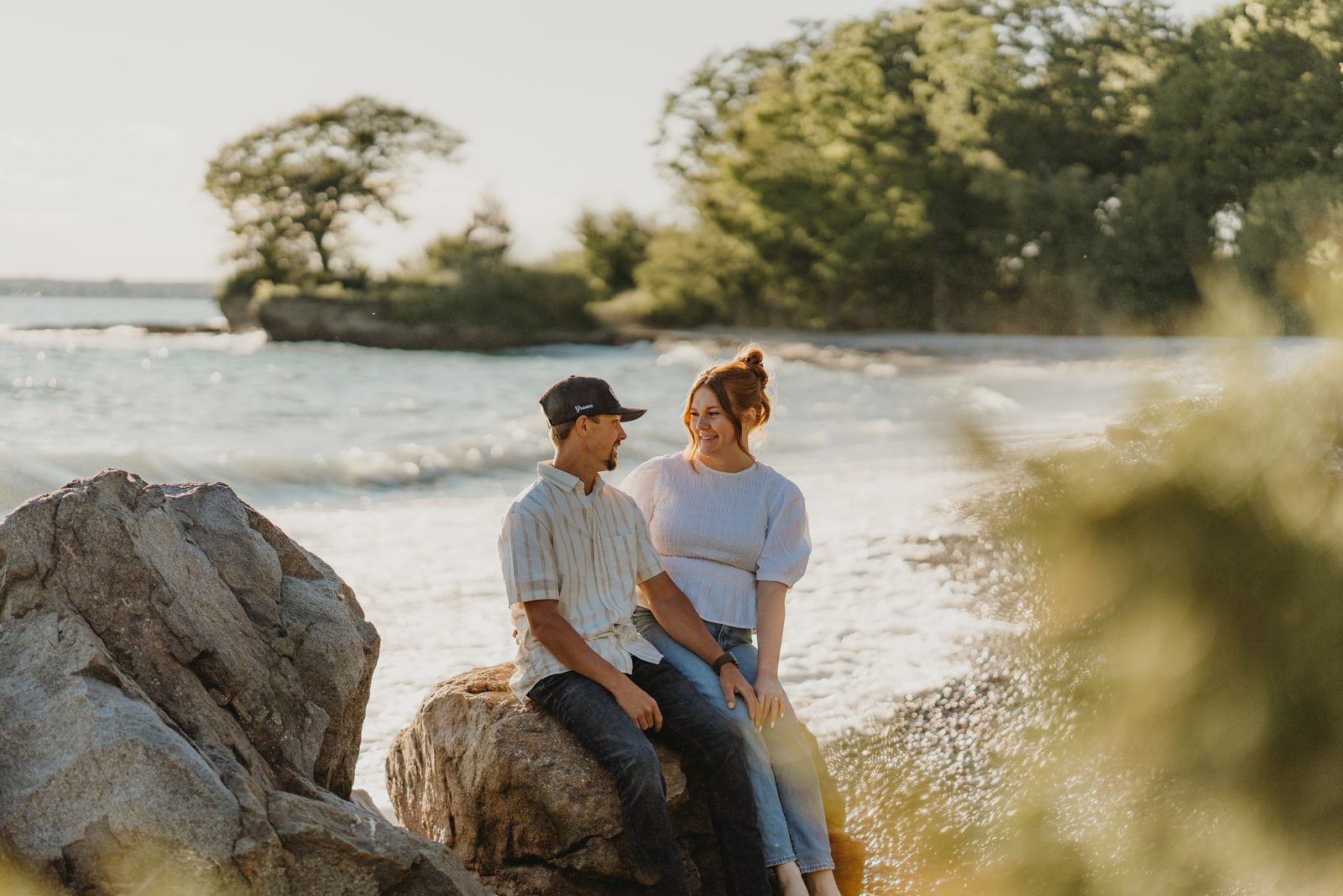 Couple laughing together during a Prince Edward County engagement session at Point Petre