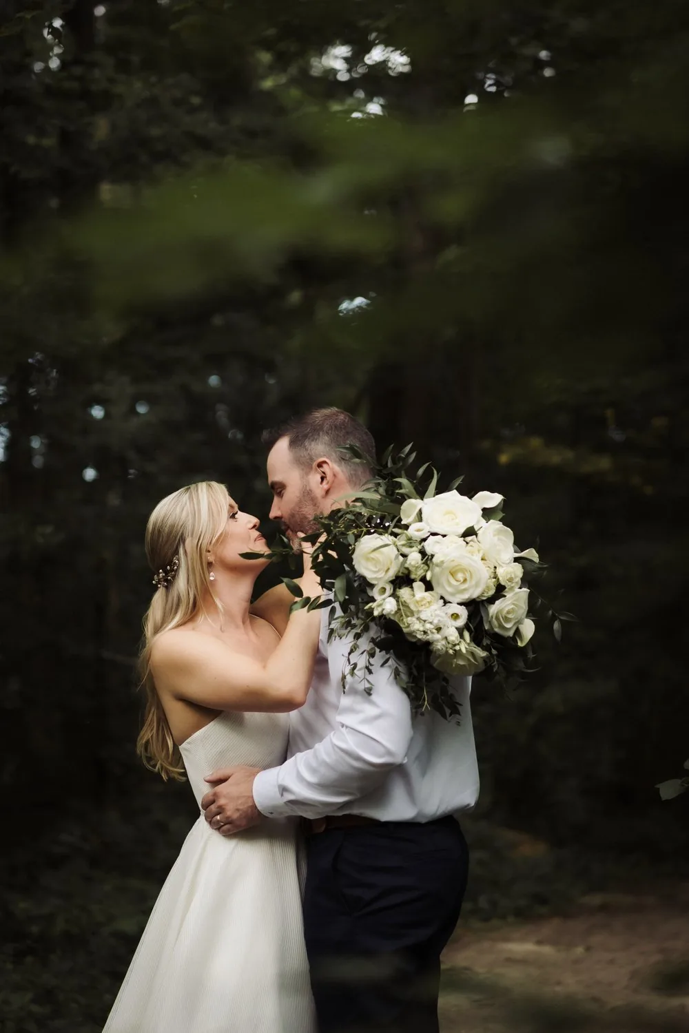 Newlywed couple embracing among greenery at an intimate at-home wedding in Ontario
