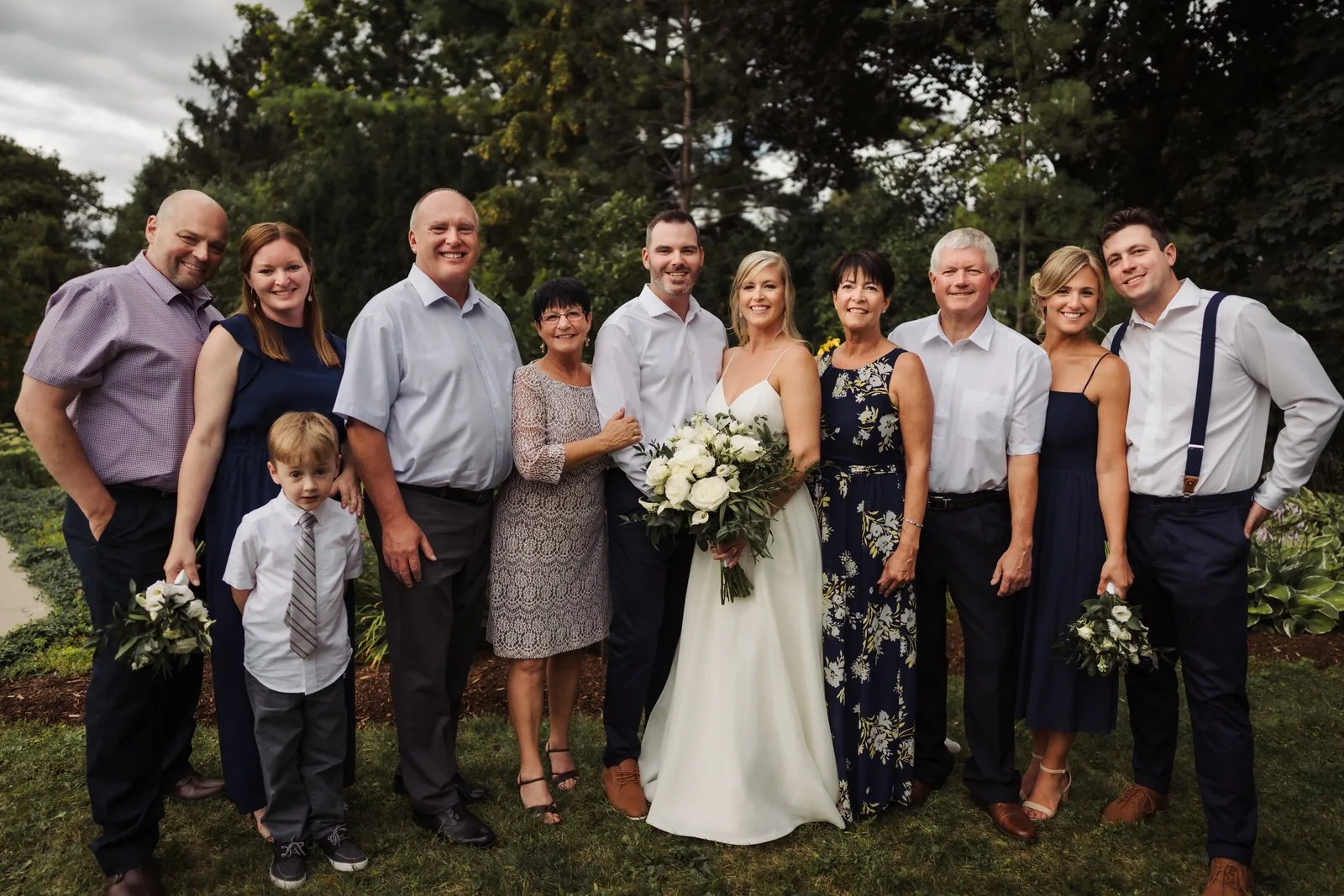 Full wedding party in navy gathered on the lawn at a backyard wedding near Kitchener, Ontario