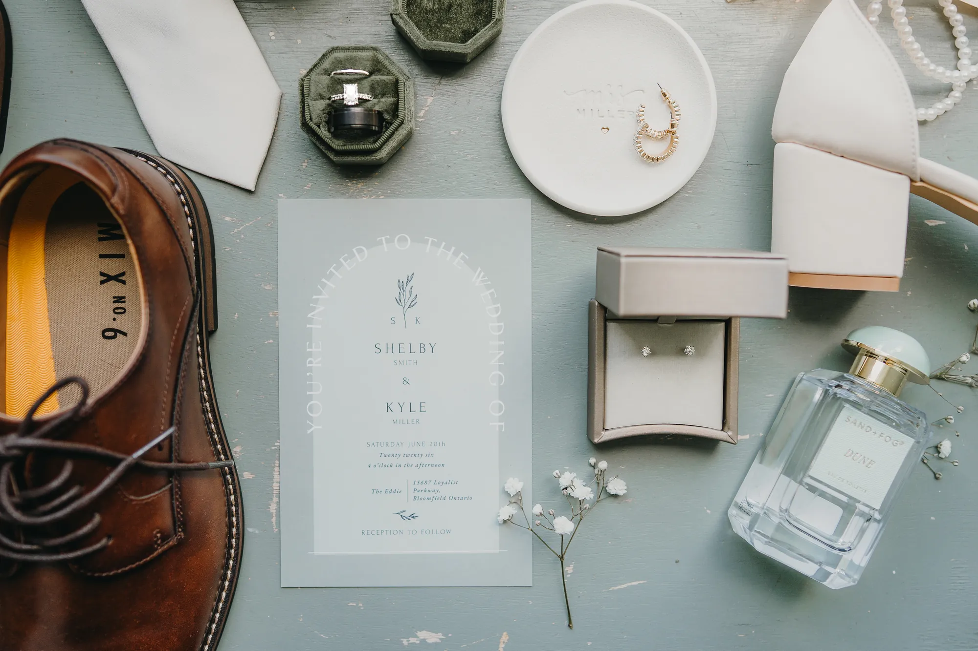 Wedding invitation, rings, earrings, and shoes flat lay for Shelby and Kyle's wedding