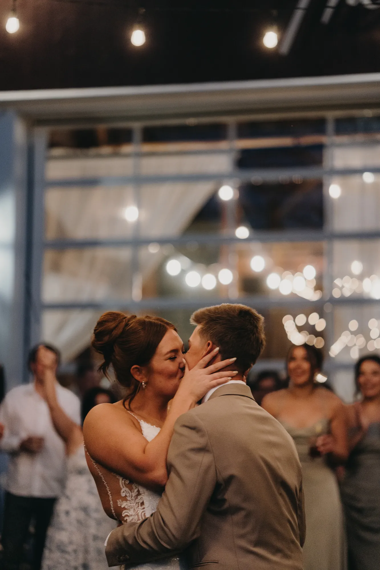 Bride and groom's first dance under string lights indoors