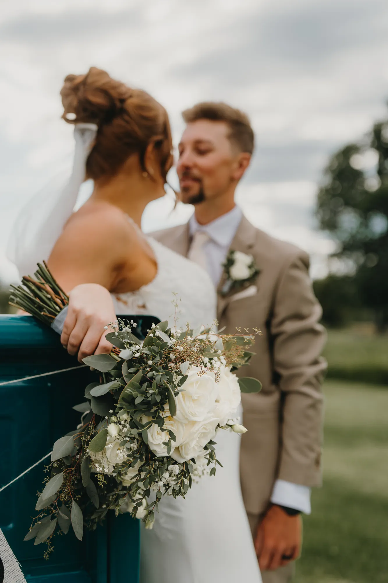 Bride and groom portrait leaning on a vintage truck at The Eddie Hotel & Farm
