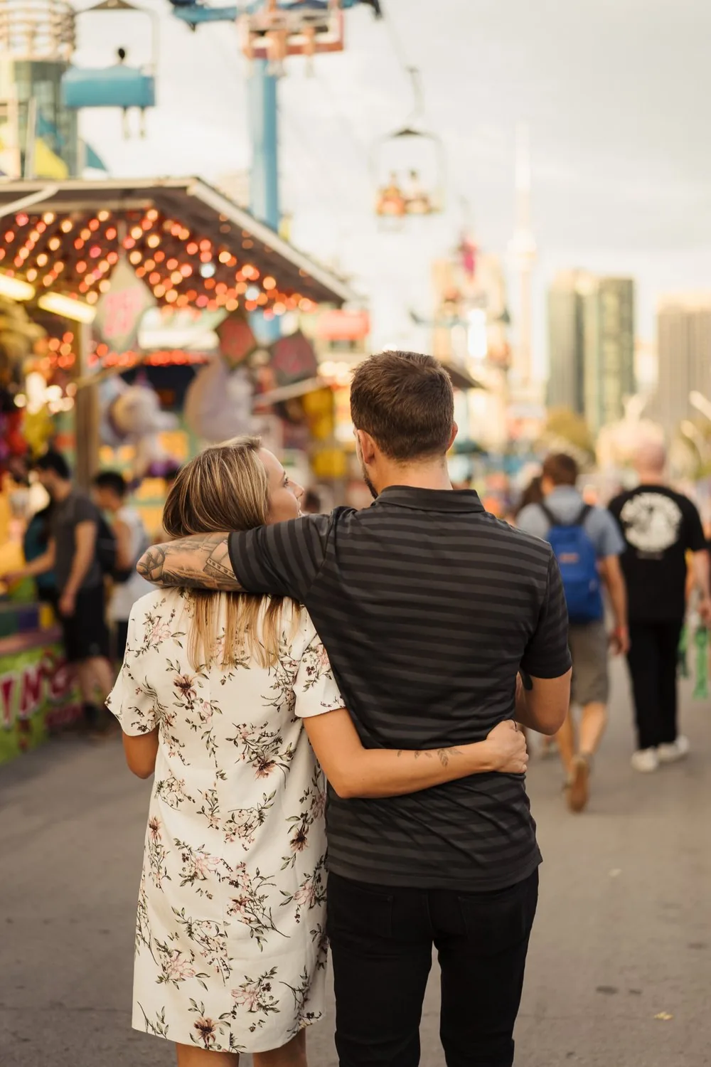 Couple walking arm in arm through the fairground at the CNE in Toronto